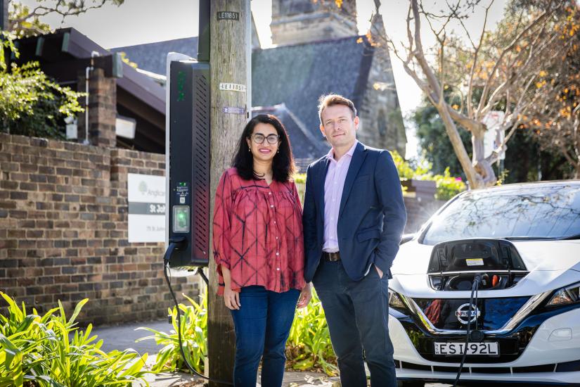 Researchers standing in front of an EV charging station